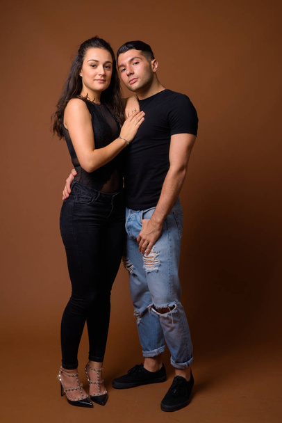 Young couple together and in love against brown background - Φωτογραφία, εικόνα
