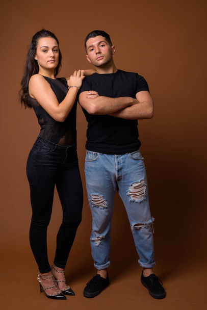 Young couple together and in love against brown background - Foto, immagini