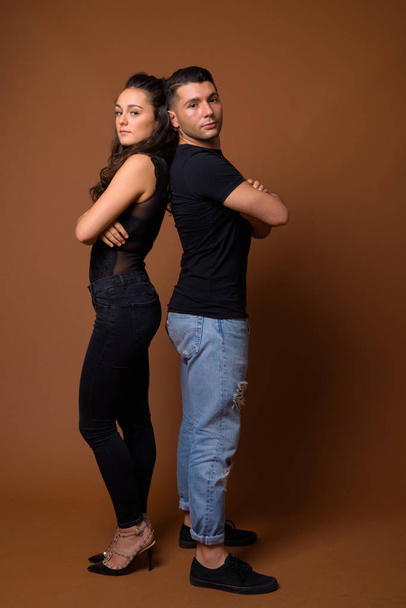 Young couple together and in love against brown background - Фото, зображення
