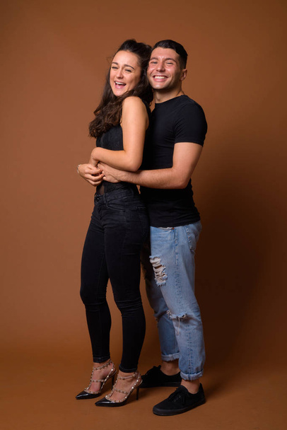 Young couple together and in love against brown background - Fotó, kép
