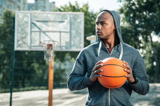 Serious young man looking at the basketball court - Foto, Imagen