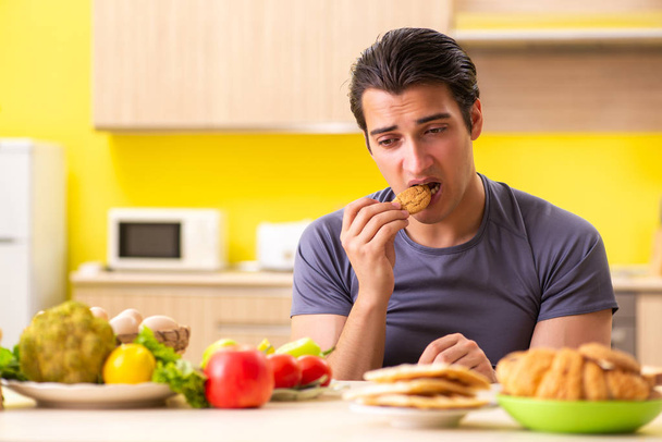 Man having hard choice between healthy and unhealthy food - Photo, Image