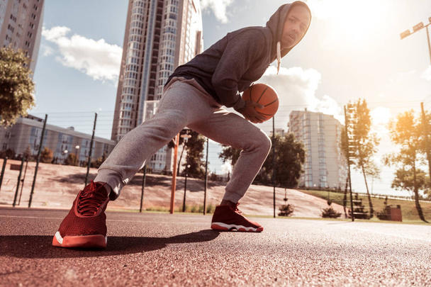 Low angle of a handsome young man playing basketball - Foto, Bild