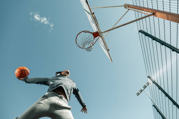 Low angle of a basketball player jumping - Foto, Imagen