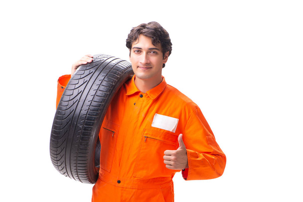 Jeune ouvrier de garage avec pneu isolé sur blanc - Photo, image