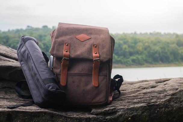 Туристический рюкзак на скале с видом на горы и реку
. - Фото, изображение