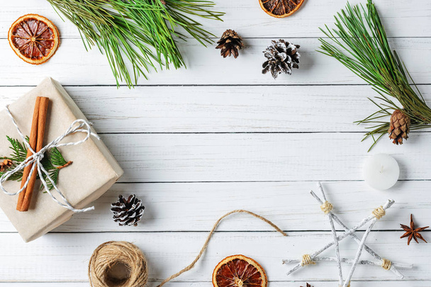 Çerçeve hediye kutuları, çam kozalakları ve beyaz ahşap zemin üzerinde kurutulmuş portakal ile. Noel süslemeleri - Fotoğraf, Görsel