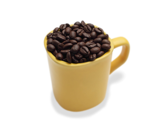 coffee beans in a yellow ceramic mug. Yang isolated white backgr - Foto, afbeelding