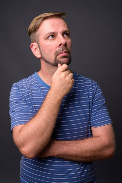 Бородатый блондин с козлиной бородкой на сером фоне - Фото, изображение