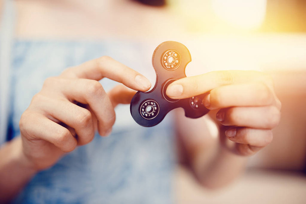 Girl to play with Fidget Spinner in his hands, the concept of relieving stress - Photo, Image