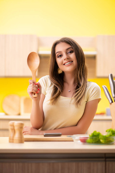 Mladá žena připravuje salát doma v kuchyni - Fotografie, Obrázek