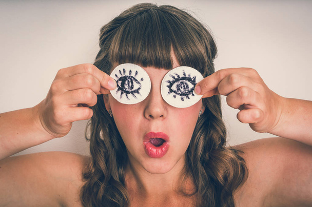 Jeune femme avec deux tampons de coton à ses yeux isolés sur fond gris - style rétro
 - Photo, image