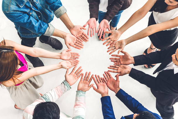 Blick von oben auf erfolgreiche Gruppenunternehmer, die gemeinsam im Büro die Hände mit offenen Handflächen zeigen. - Foto, Bild