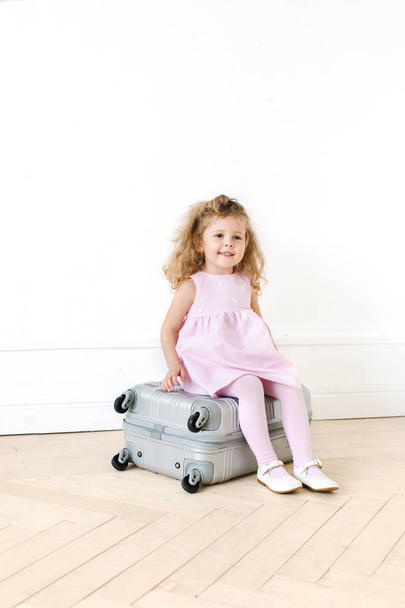 Adorable girl on suitcase - Photo, Image