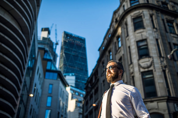Hipster businessman with sunglasses standing on the street in city. Copy space. - Foto, Imagen