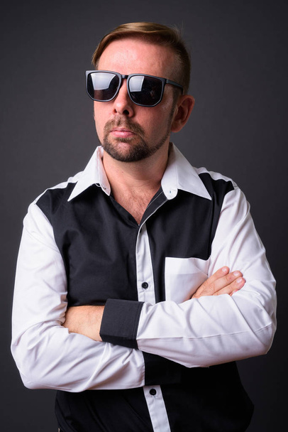 Blond vousatý podnikatel s bradkou proti šedému pozadí - Fotografie, Obrázek