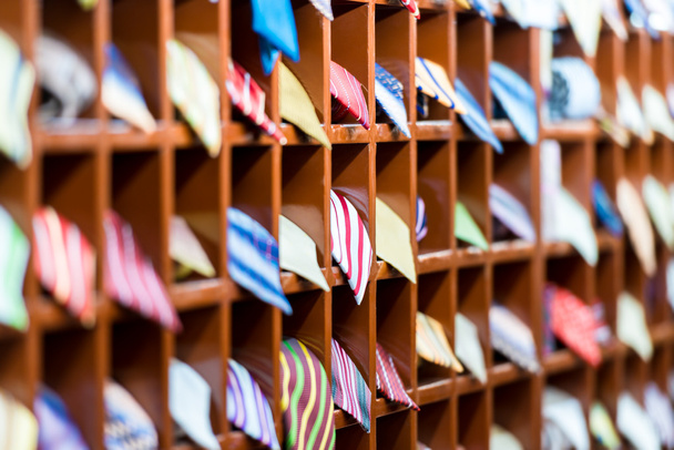 Рядки полиць з різнокольоровими краватками в магазині
. - Фото, зображення