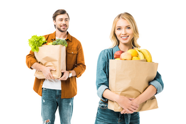beautiful girl holding paper bag with food while her boyfriend standing behind isolated on white - Φωτογραφία, εικόνα