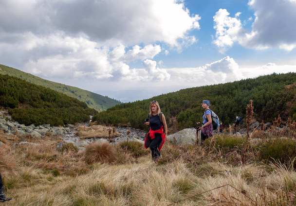 Vysoke Tatry, Slovakia - October 9, 2018: Hikers on trail at Great Cold Valley,  Vysoke Tatry (High Tatras), Slovakia. The Great Cold Valley is 7 km long valley, very attractive for tourists - Photo, Image
