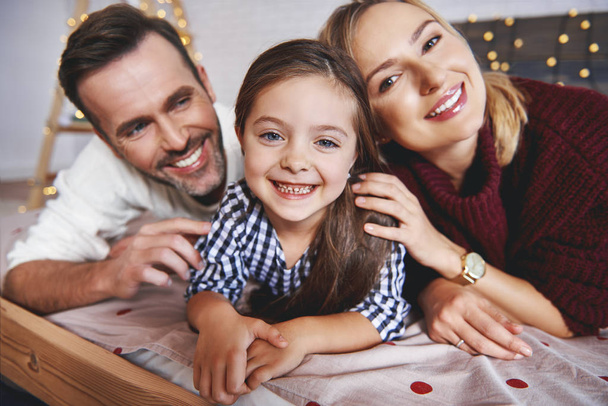 Ritratto di famiglia sdraiato a letto nel periodo natalizio
  - Foto, immagini