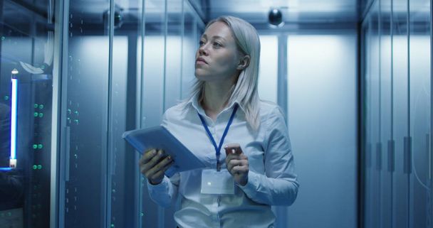 Female technician works on a tablet in a data center - Photo, Image