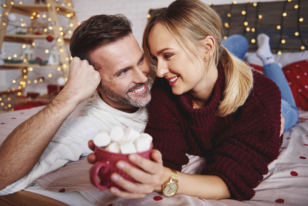 Glimlachende man zijn vriendin omarmen in kerst - Foto, afbeelding