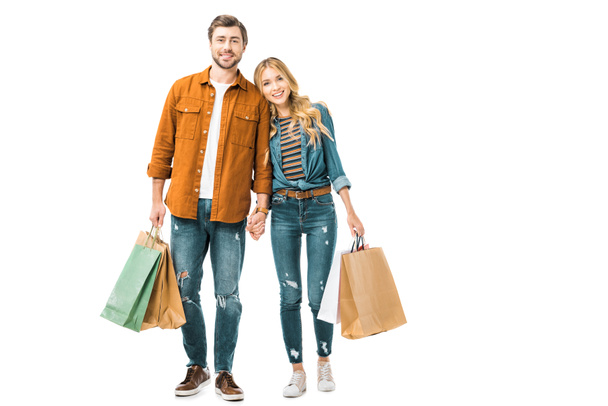 cheerful couple holding colorful shopping bags isolated on white - 写真・画像