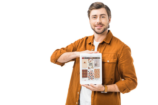 homem feliz mostrando tablet digital com pinterest na tela isolado em branco
 - Foto, Imagem