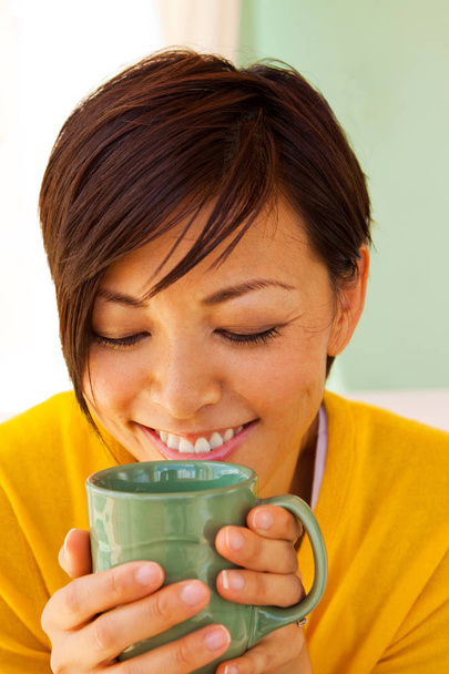 Happy Asian woman smiling and drinking coffee. - Fotó, kép