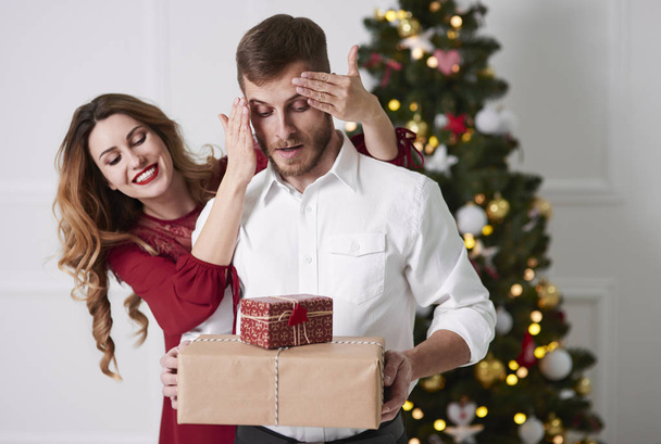 Woman giving gifts to surprised man  - Photo, Image