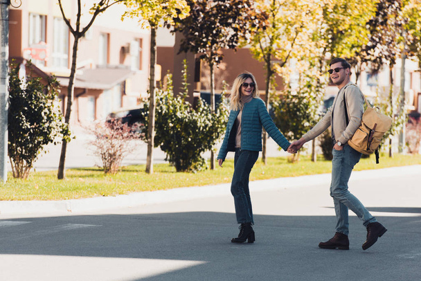 ζευγάρι κρατώντας τα χέρια, ενώ το περπάτημα μαζί στην πόλη της νέας - Φωτογραφία, εικόνα