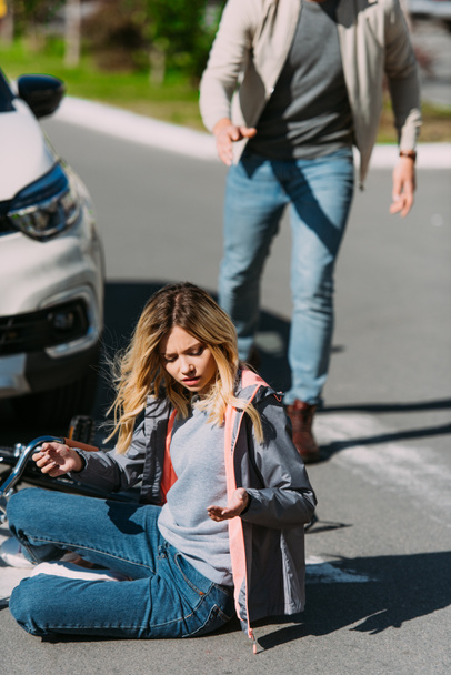 道路の背後にある車のドライバーと車の事故の後で傷つけられた女性の選択と集中  - 写真・画像