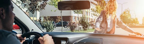 Молодая женщина ссорится с водителем автомобиля во время перехода дороги
 - Фото, изображение