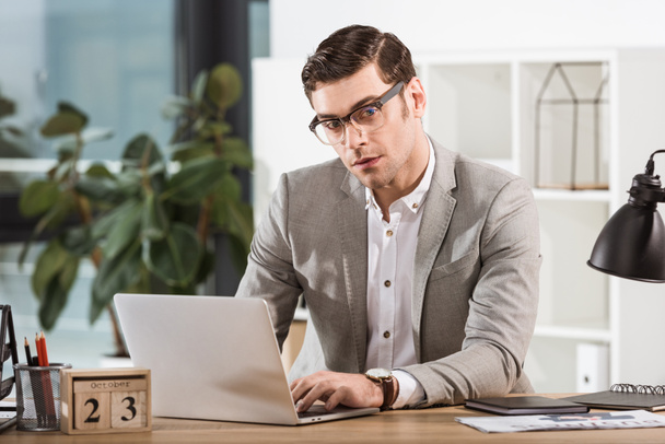 handsome stylish businessman working with laptop at office - Photo, Image