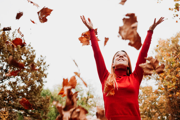 Genç kadın sonbahar atma park havada bırakır - Fotoğraf, Görsel