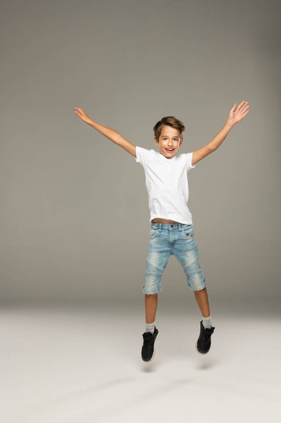 Happy jumping boy in studio - Фото, изображение