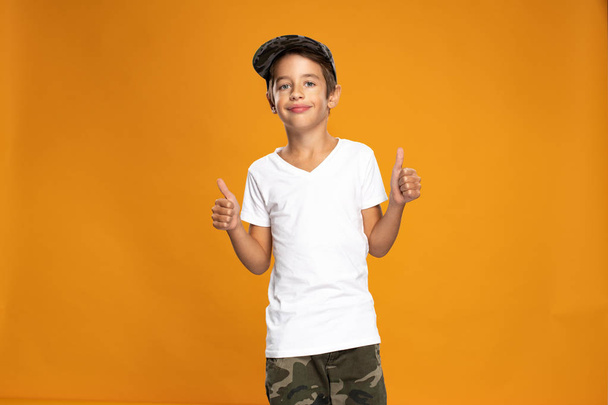 Happy young boy over yellow background - Foto, afbeelding