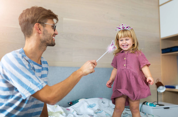 Vater zieht Tochter mit Zauberstab in seinen Bann - Foto, Bild