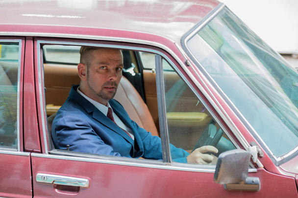 Retrato de homem de negócios loiro dirigindo carro vintage
 - Foto, Imagem
