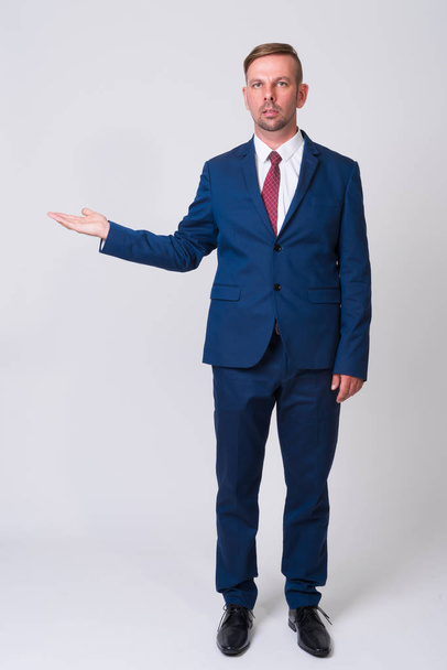 Ganzkörperaufnahme eines blonden Geschäftsmannes im blauen Anzug - Foto, Bild