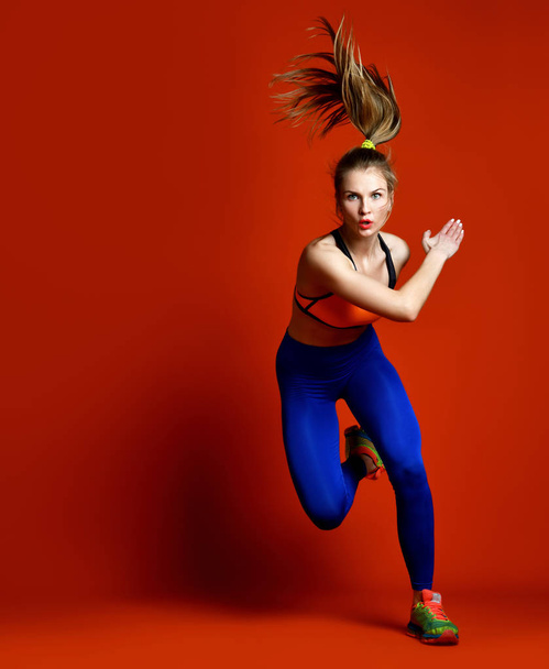Runner woman isolated. Running fit fitness sport model jogging isolated on red background.  - Photo, image