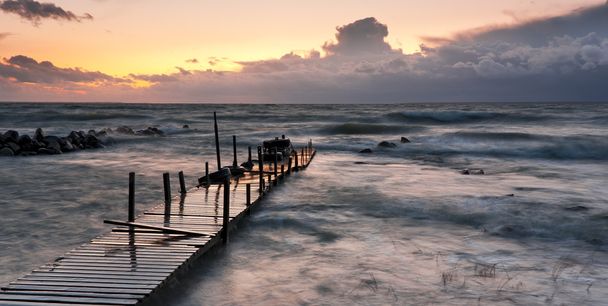 Pont en bois en mer au coucher du soleil
 - Photo, image