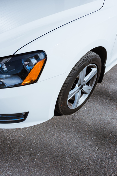 ヘッドライトのイメージと道路に白い新しい車のホイールをトリミング - 写真・画像