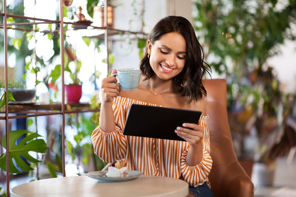 happy woman with tablet pc at cafe or coffee shop - Photo, image