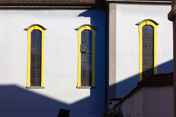 église catholich avec façade jaune bleu sur ciel bleu soleil jour de printemps dans la ville sud-allemande schwaebisch gmuend près de stuttgart
 - Photo, image