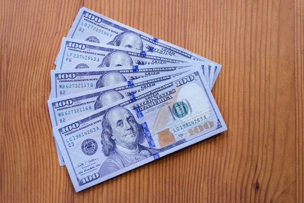 dinheiro de papel, dólar americano, notas de cem dólares numa mesa de madeira, close-up
 - Foto, Imagem