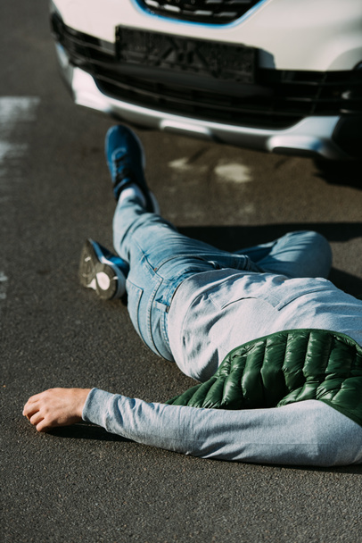 rajattu kuva uhrista makaamassa tiellä moottoriajoneuvon törmäyksen jälkeen
 - Valokuva, kuva