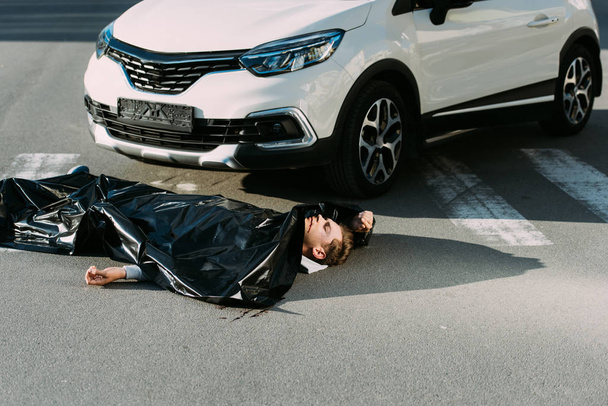 vista ad alto angolo del cadavere e dell'auto sulla strada dopo la collisione stradale
   - Foto, immagini