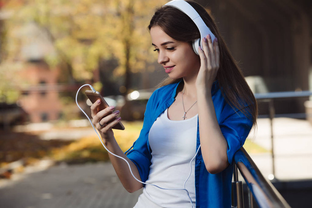Young woman listening to music with headphones in urban city - Zdjęcie, obraz