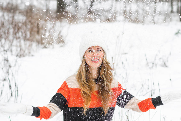 Nuori onnellinen nainen talvivaatteissa kävelee lumisessa metsässä
 - Valokuva, kuva